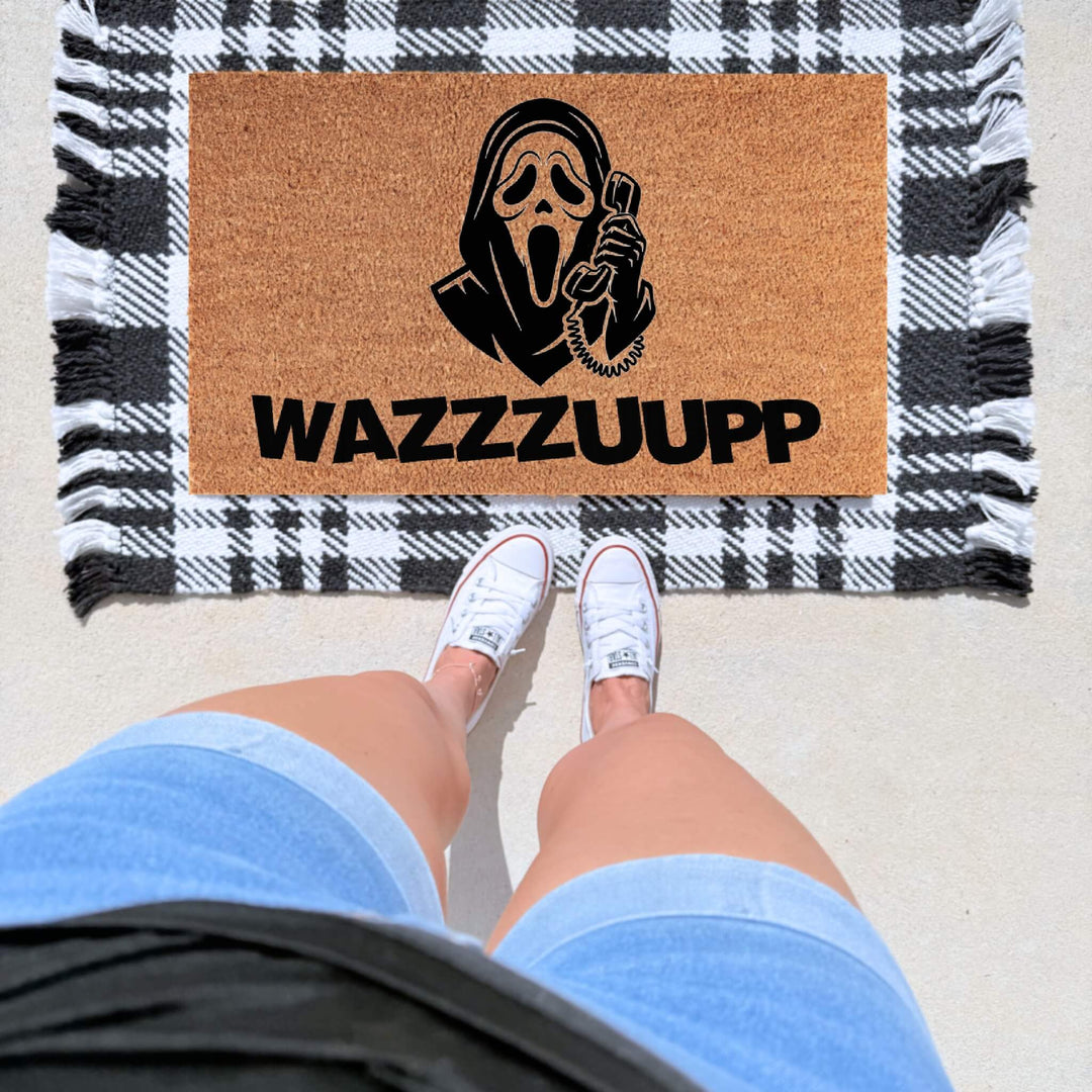 WAZZZZUUPP doormat featuring a Ghost Face inspired design on a natural coir welcome mat for Halloween décor and horror movie lovers.
