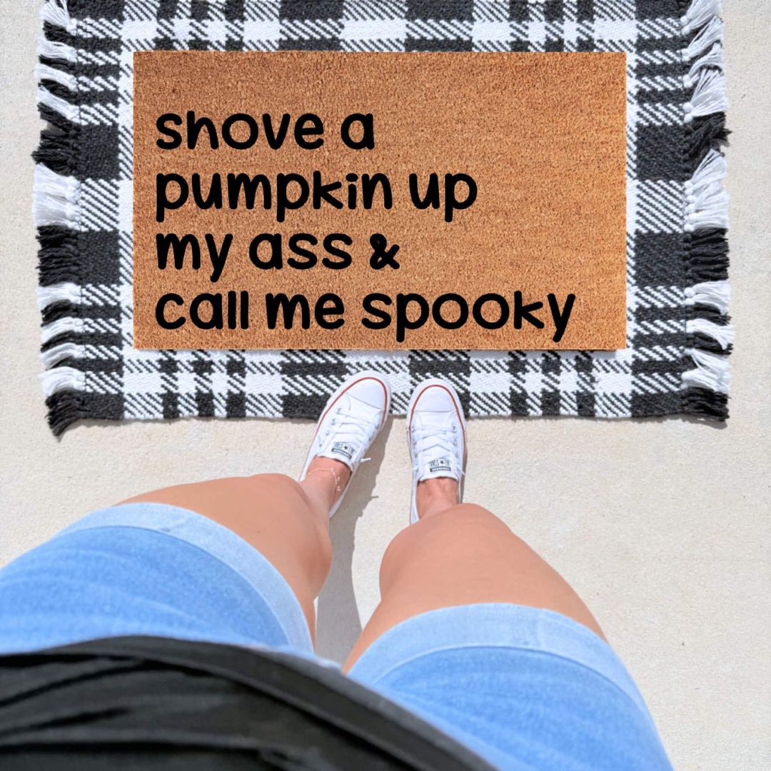 Funny adult Halloween doormat featuring the phrase "Shove a Pumpkin Up My Ass and Call Me Spooky" on a natural coir welcome mat.